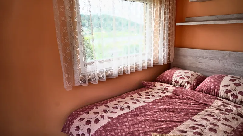 Łóżko dwuosobowe i okno z widokiem na dolinę
